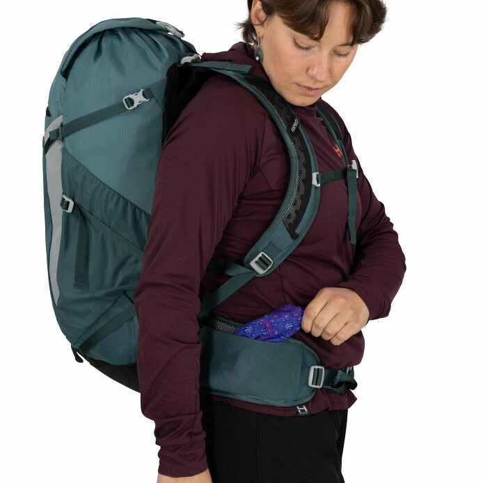 Teal hiking backpack close-up with zipper hip belt pocket and hand opening compartment