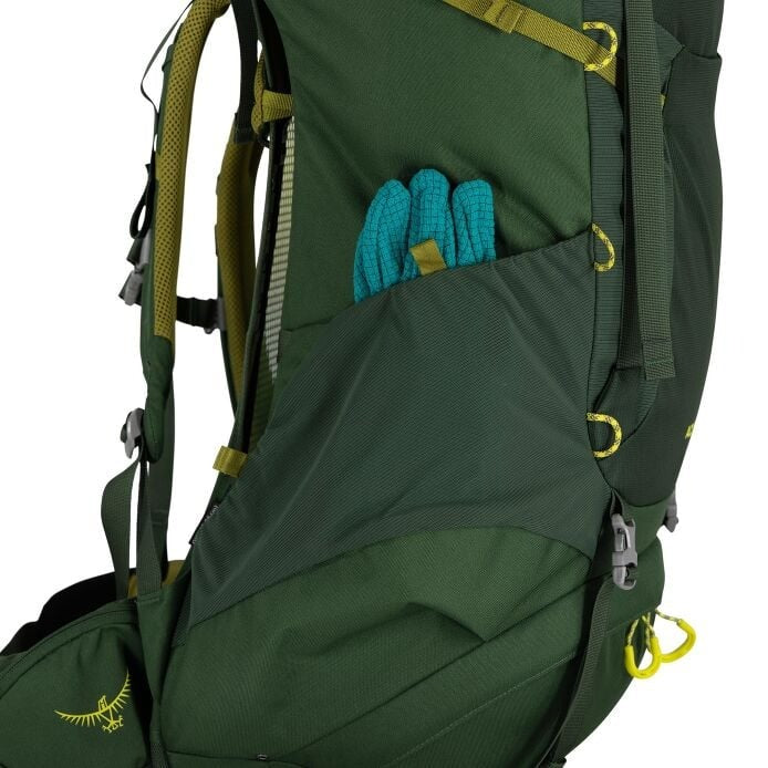 Green hiking backpack with a pocket containing blue gloves on a white background