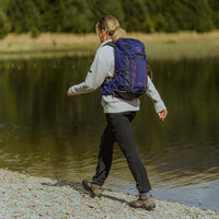Person with a purple backpack walking along a lakeside path