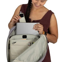 Woman holding a tablet and phone over an open backpack with a white background