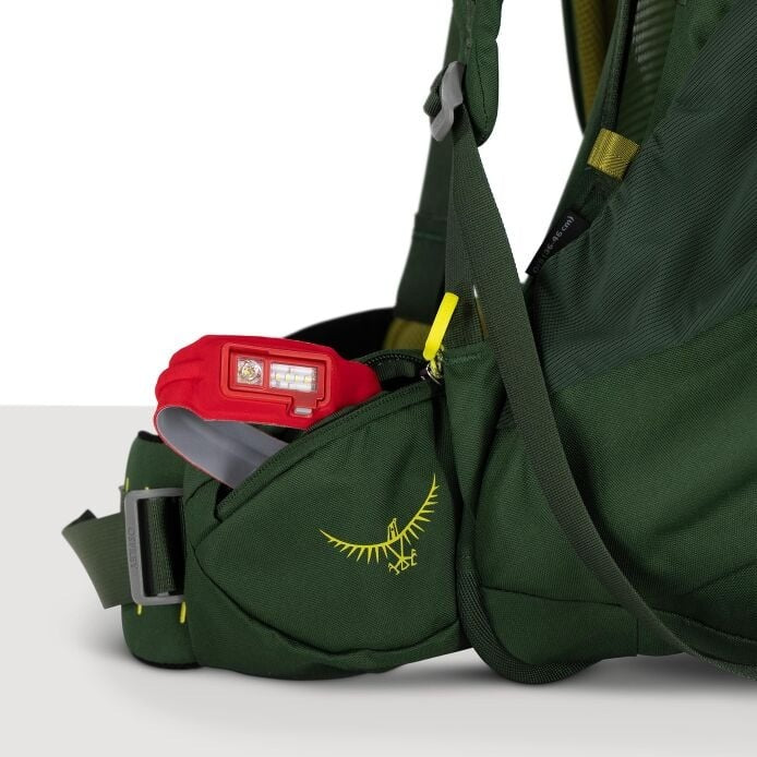 Green backpack with a red item inside on a white background