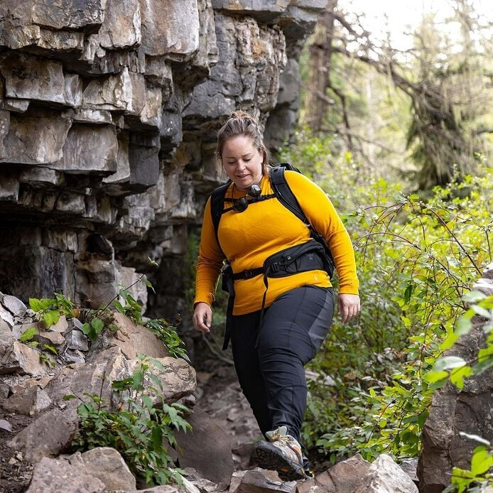 Person hiking through a rocky landscape with greenery