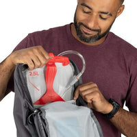 Man opening a backpack with a red and white container inside