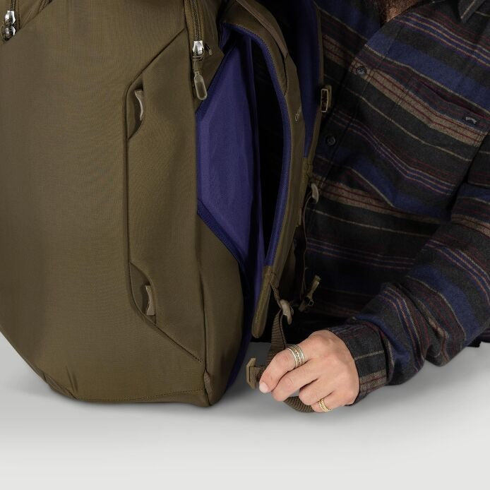 Olive travel pack side pocket with dark blue interior panel and zipper pulls