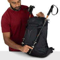 Black hiking backpack with trekking pole attachment straps and compression webbing