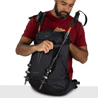 Black hiking backpack with side straps and trekking pole holders attached