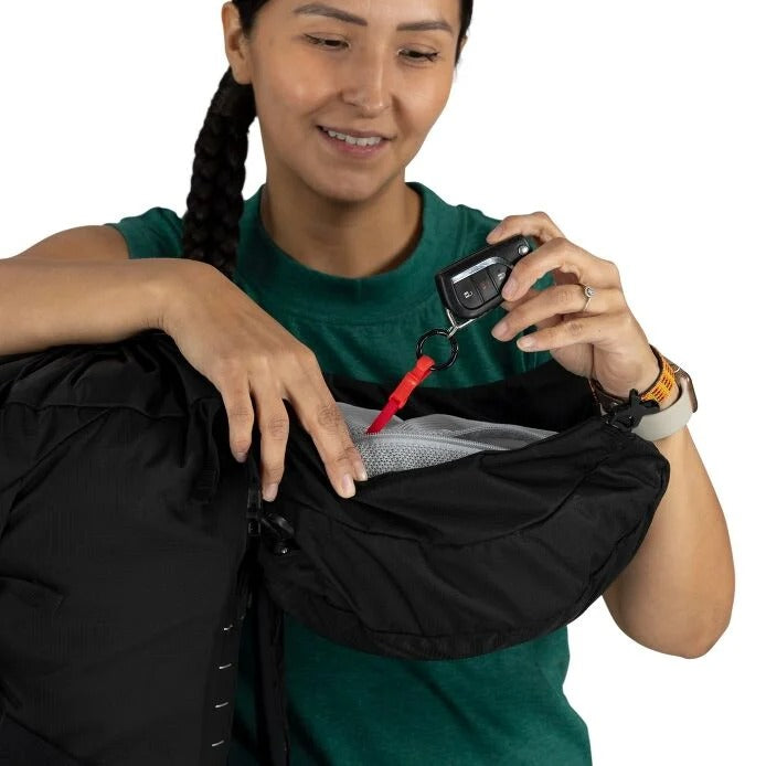Person holding a black bag and a key fob with a white background