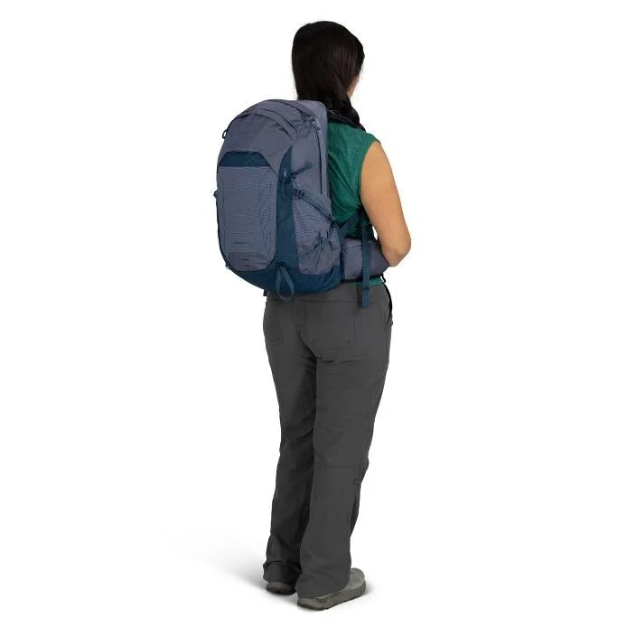 Person wearing a large blue backpack on a white background