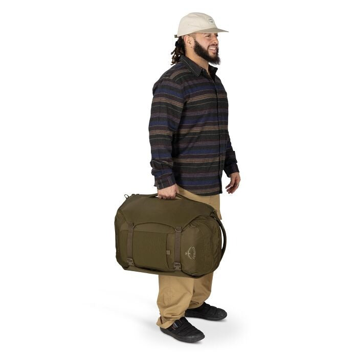 Olive green travel backpack worn by a person, side view with shoulder straps