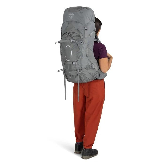 Person wearing a large gray backpack on a white background