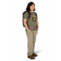 Person wearing a green t-shirt with a graphic design, beige pants, and a purple backpack on a white background
