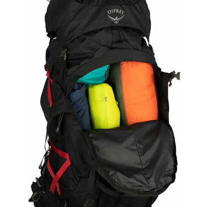 Black Osprey backpack with colorful items inside on a white background