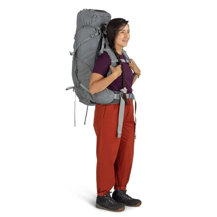 Person wearing a large gray backpack on a white background