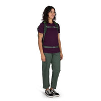 Person wearing a purple shirt and green pants with a backpack on a white background