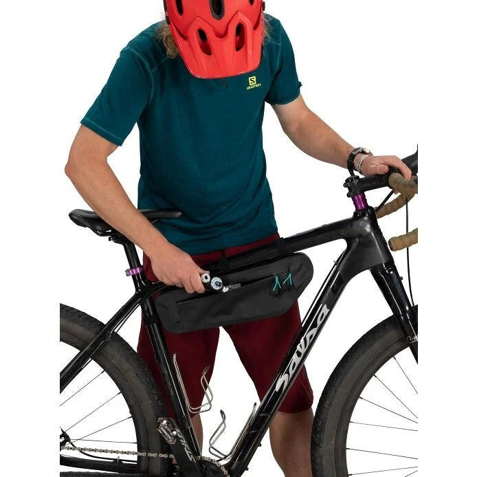 Person holding a bicycle with a black frame and red helmet on a white background