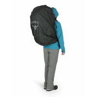 Person wearing a large black Osprey backpack on a white background
