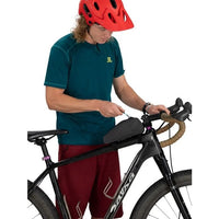 Person adjusting a bike with a helmet on a white background