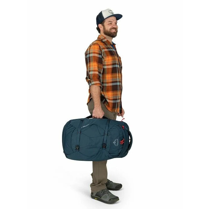 Man holding a blue duffel bag on a white background