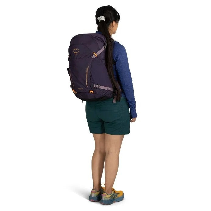 Person wearing a large purple backpack on a white background