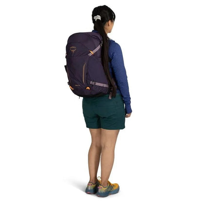 Person wearing a large purple backpack on a white background
