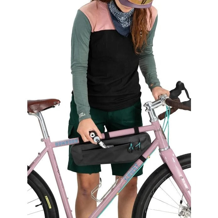 Person with a pink bicycle and a black bag on a white background