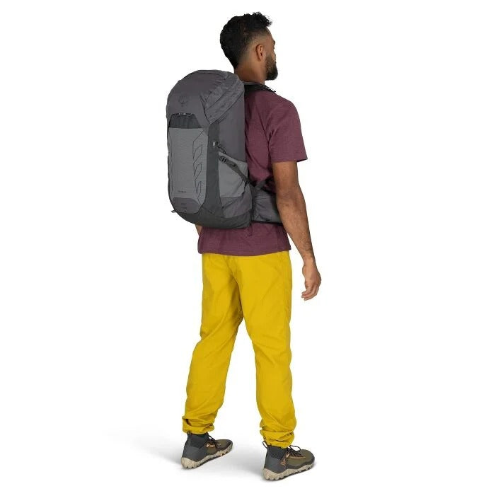 Person wearing a gray backpack and yellow pants on a white background