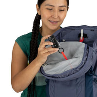 Woman holding a backpack with a keychain attached, on a white background