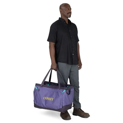Man holding a purple Osprey bag on a white background